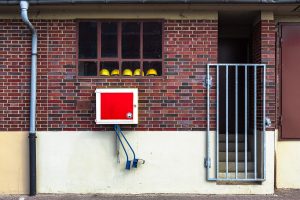 Gelbe Helme die aufgereiht hinter einem Fenster liegen